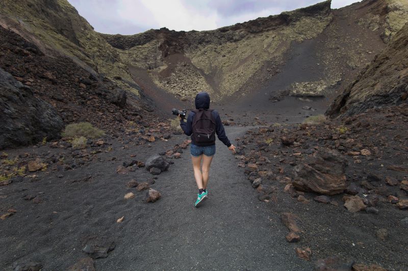ランサローテ島の火山をカメラを持って歩く人